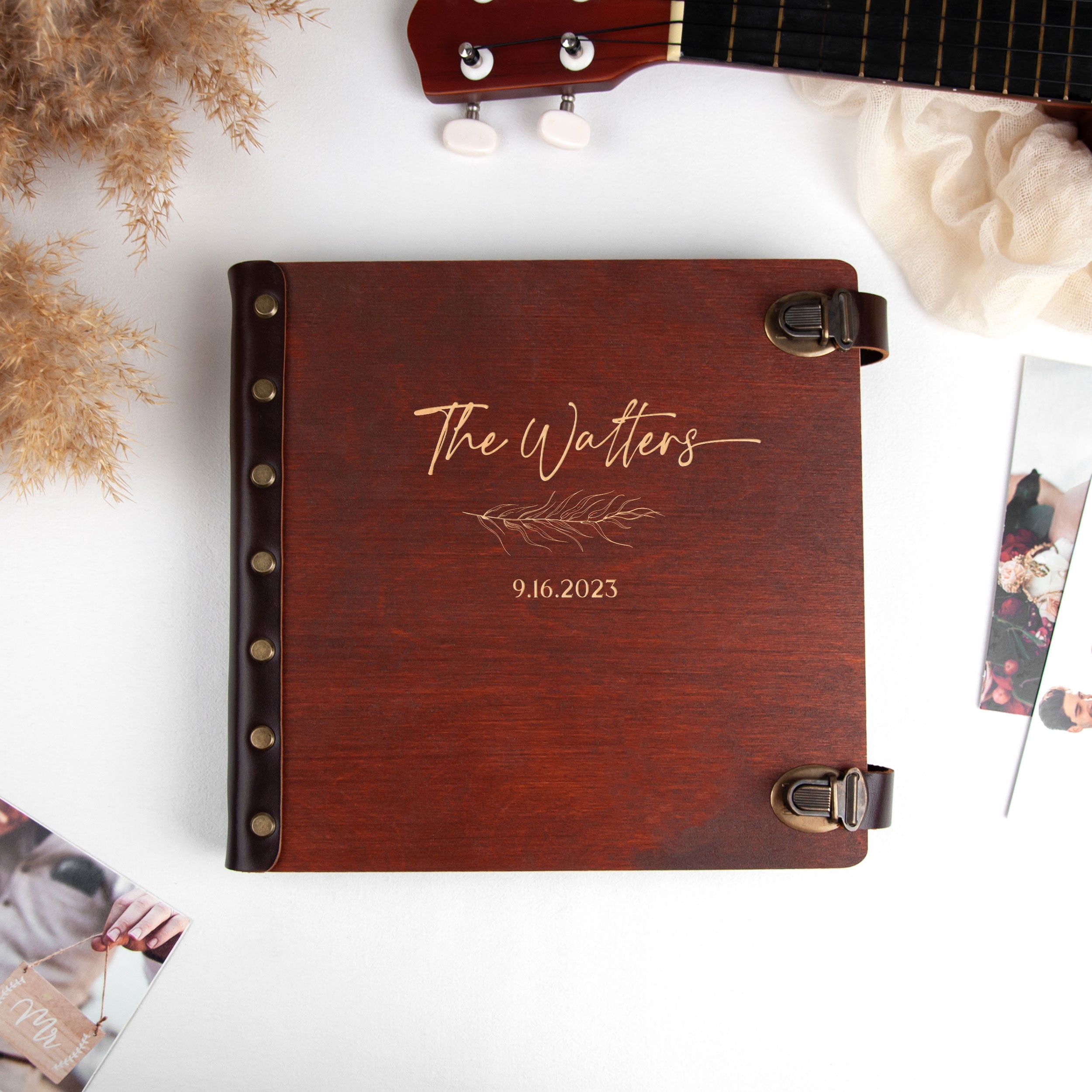 A wooden album with the name "The Waiters" and the date "9.16.2023" printed on it, along with a guitar and other personal items.