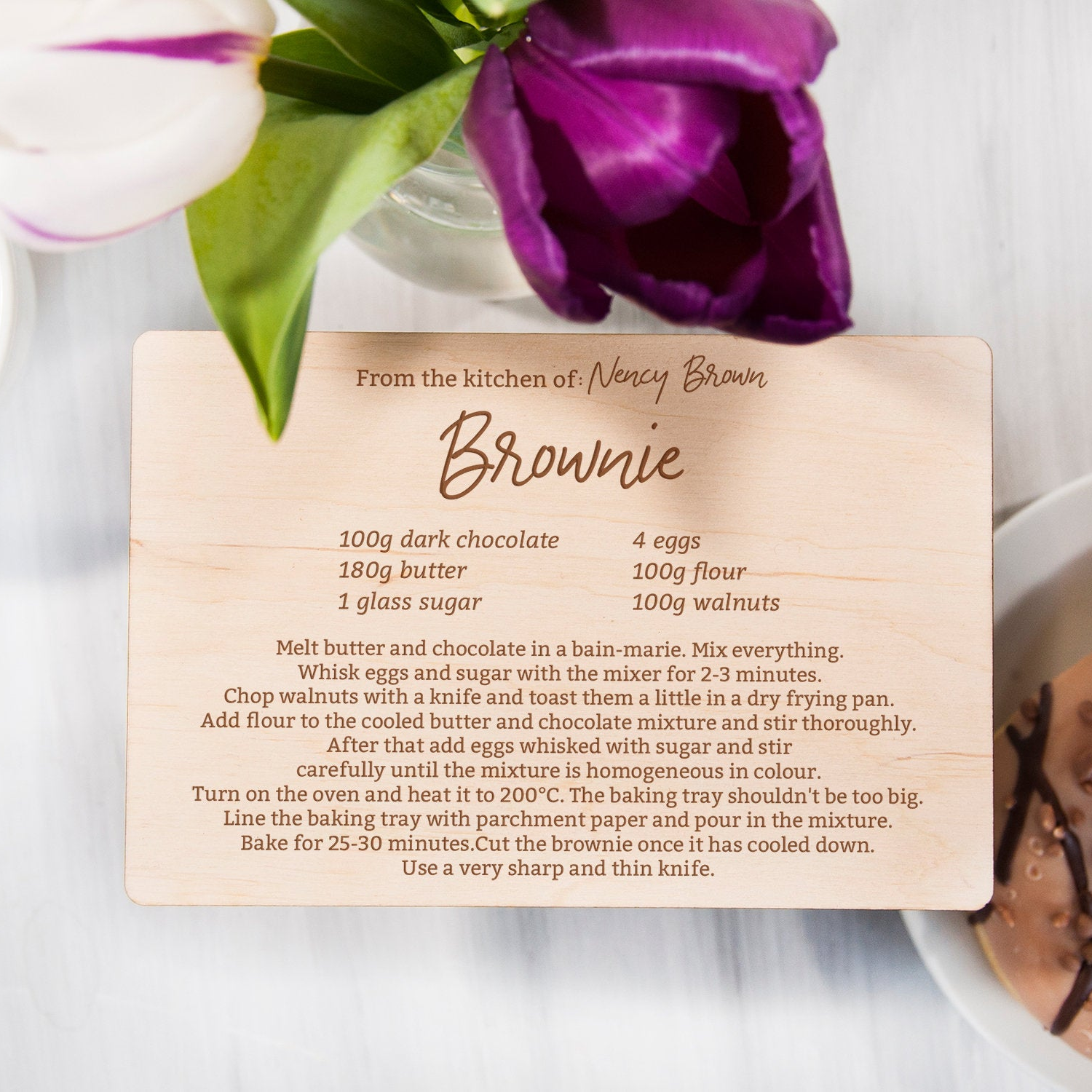 A wooden recipe card with a brownie recipe from the kitchen of Nancy Brown.