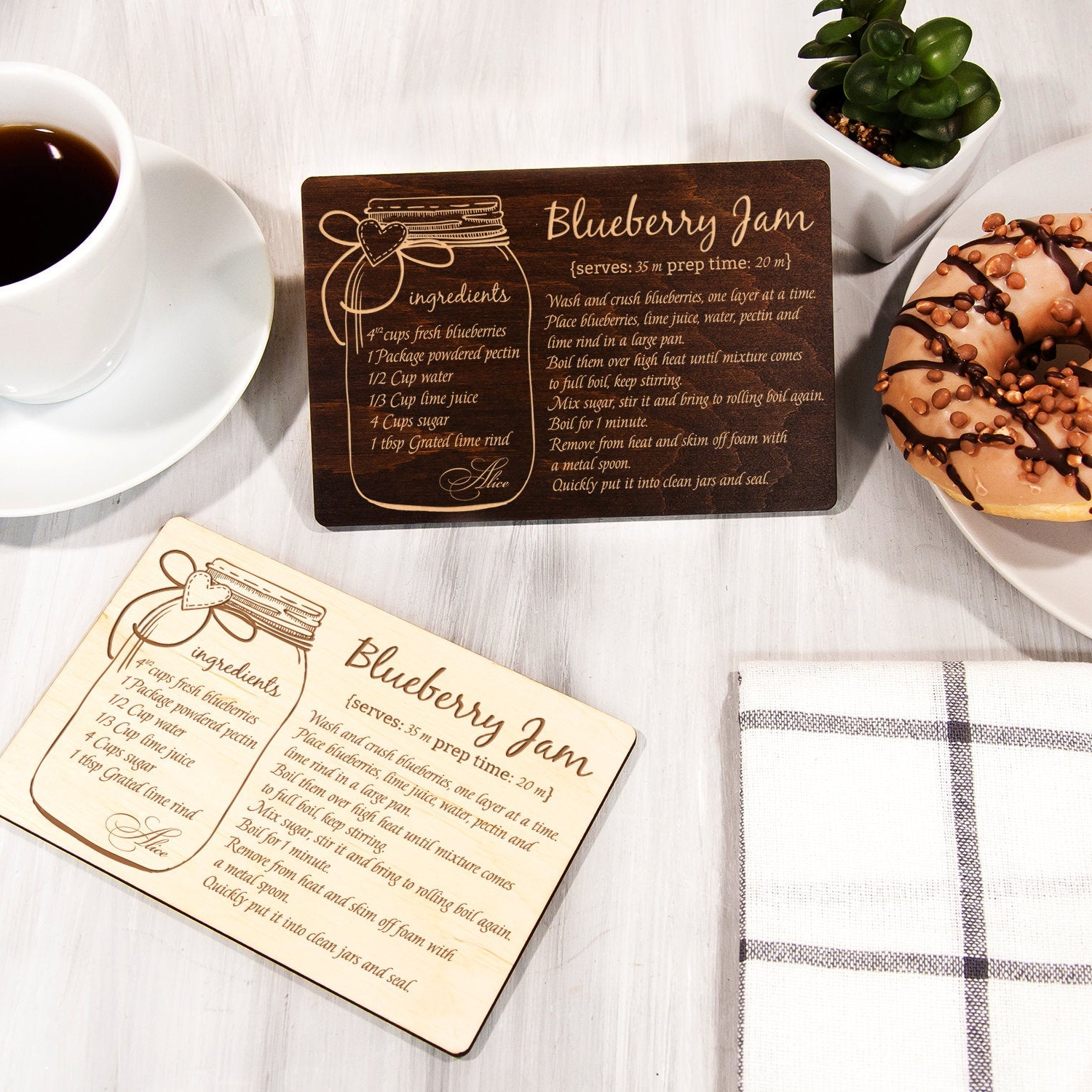a wooden coaster with a recipe for Blueberry Jam, a cup of coffee, a plate with a donut, and a small potted plant.