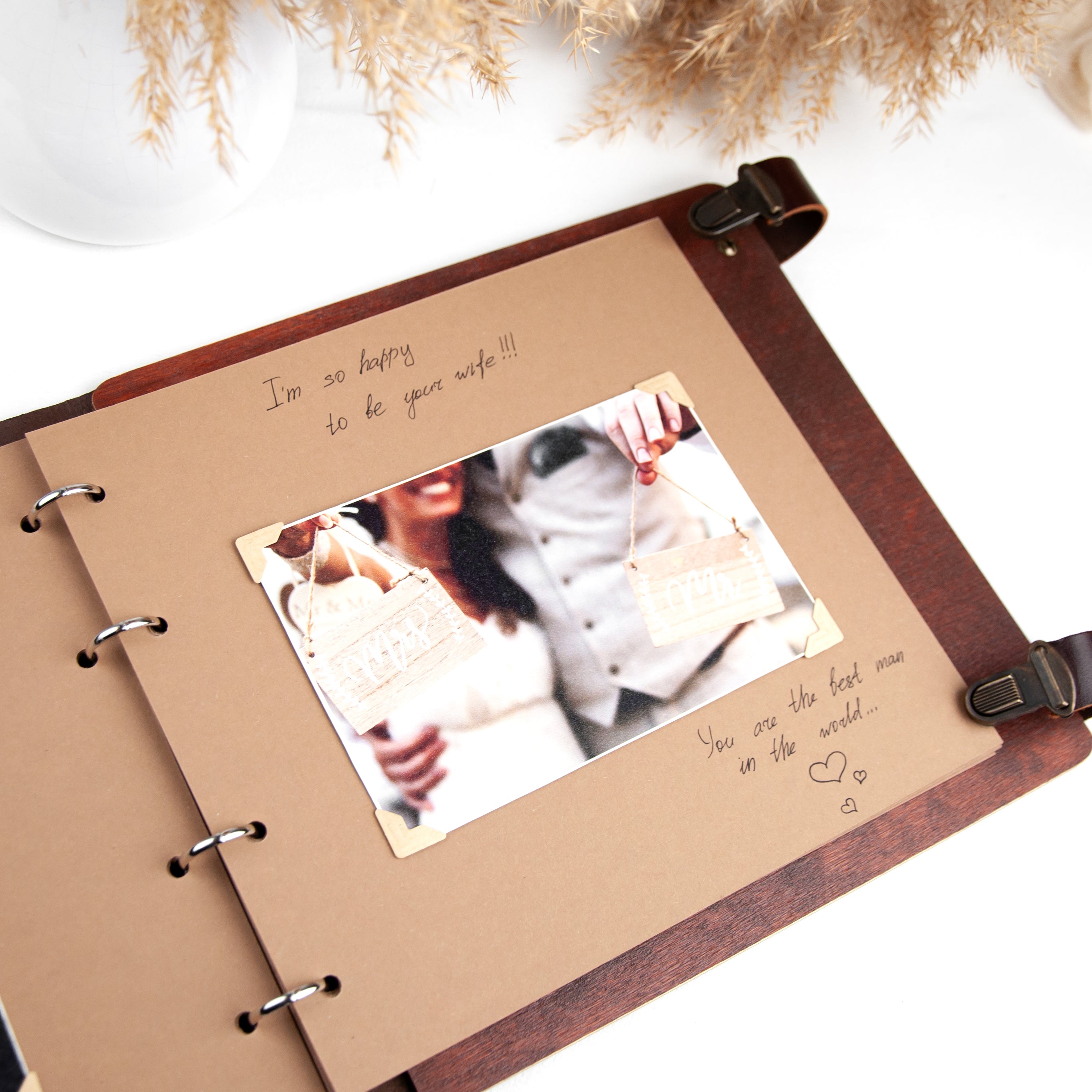 a brown photo album with a handwritten message and a photograph of a couple embracing.
