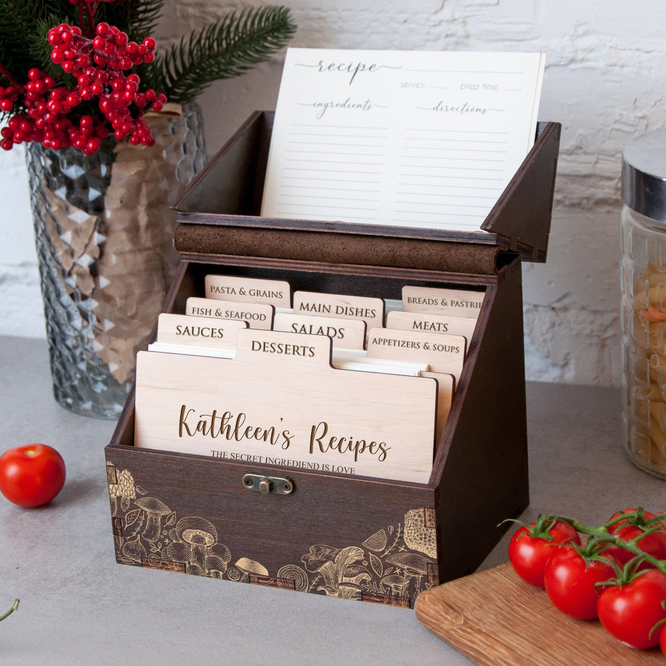 A wooden recipe box with a list of recipes, surrounded by various kitchen ingredients and a vase of red berries.