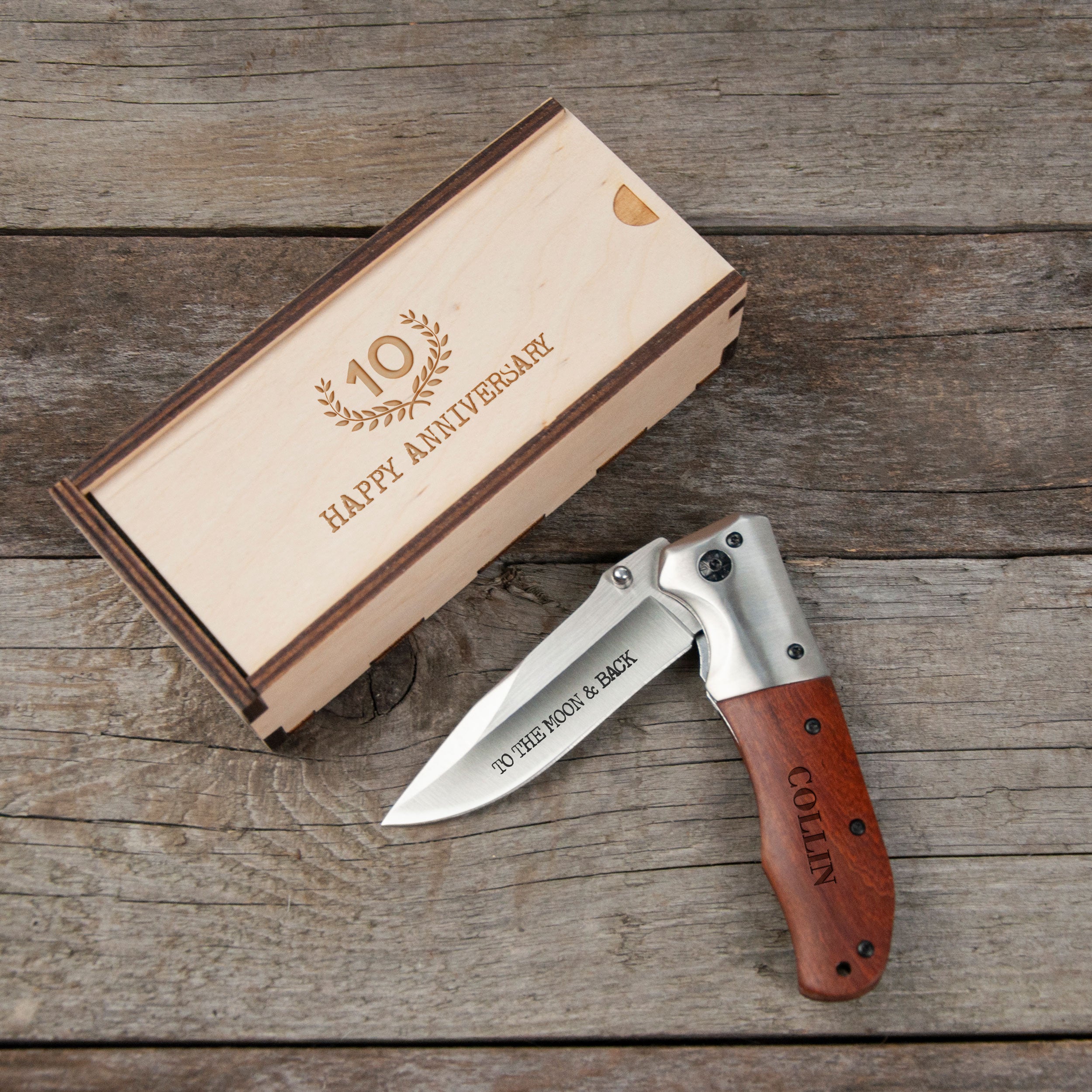 A wooden box with a knife engraved on it, placed on a wooden surface.