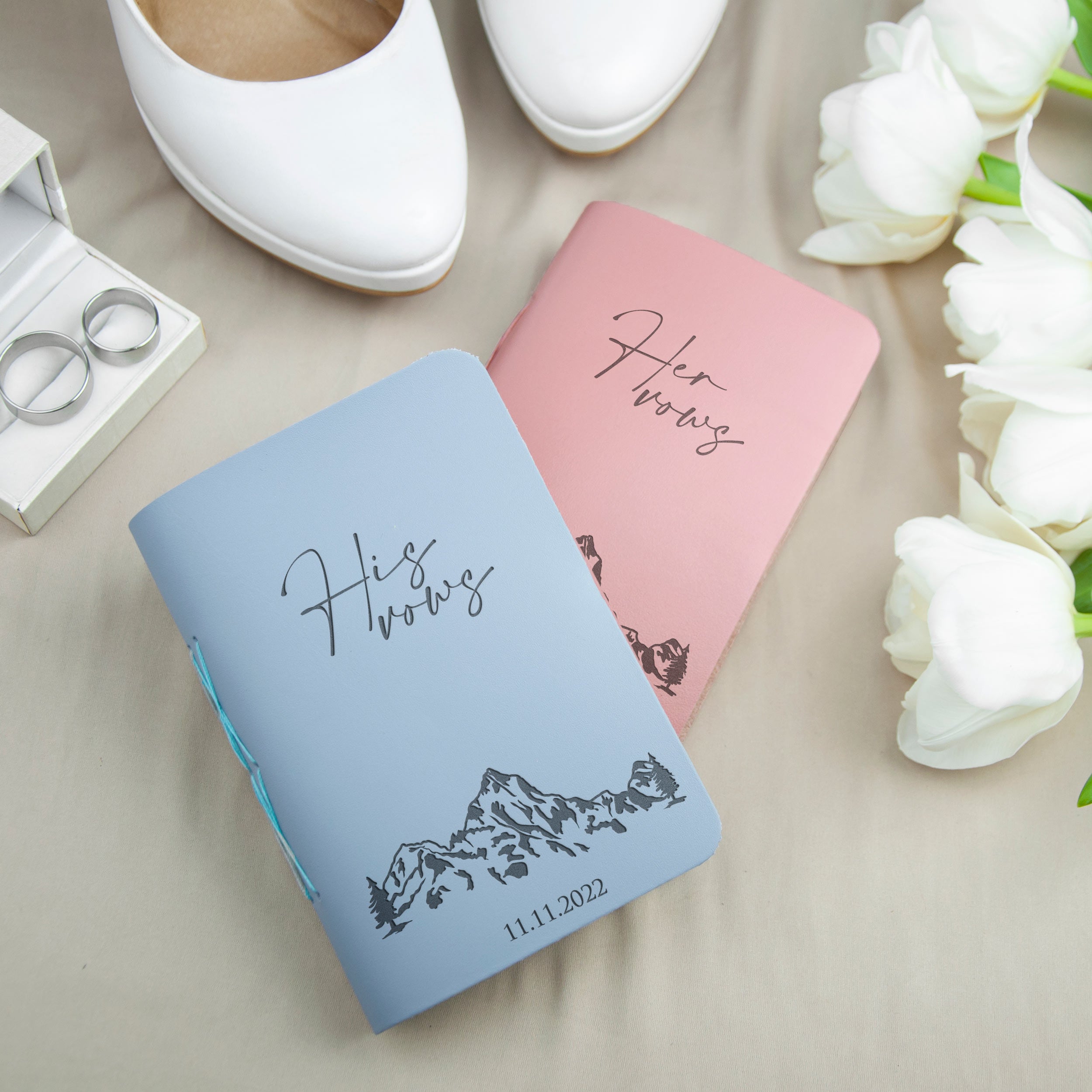 A pair of wedding vows, a pair of white shoes, and a bouquet of white roses are arranged on a table.