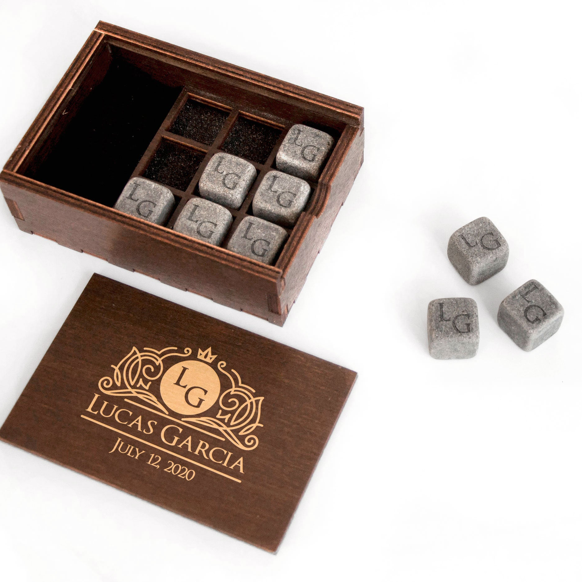 a wooden box with a set of gray stones inside, along with a wooden plaque with text and a date.