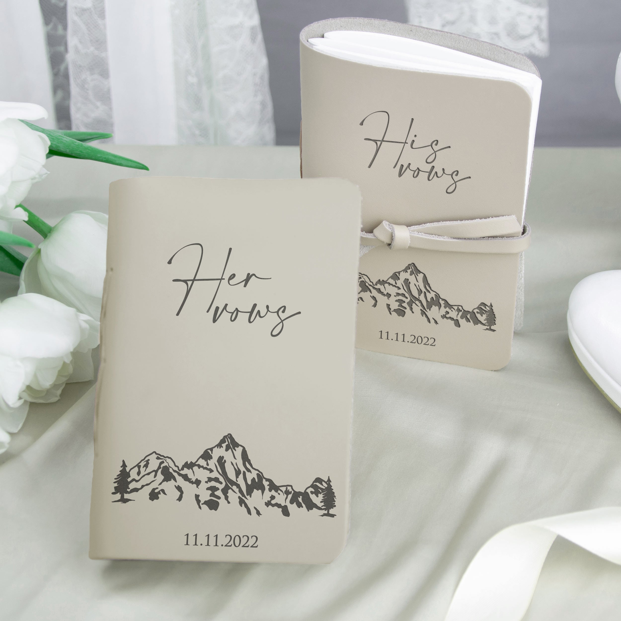 two beige notebooks with a mountain landscape design, along with the text "Her Wills" and the date "11.11.2022".