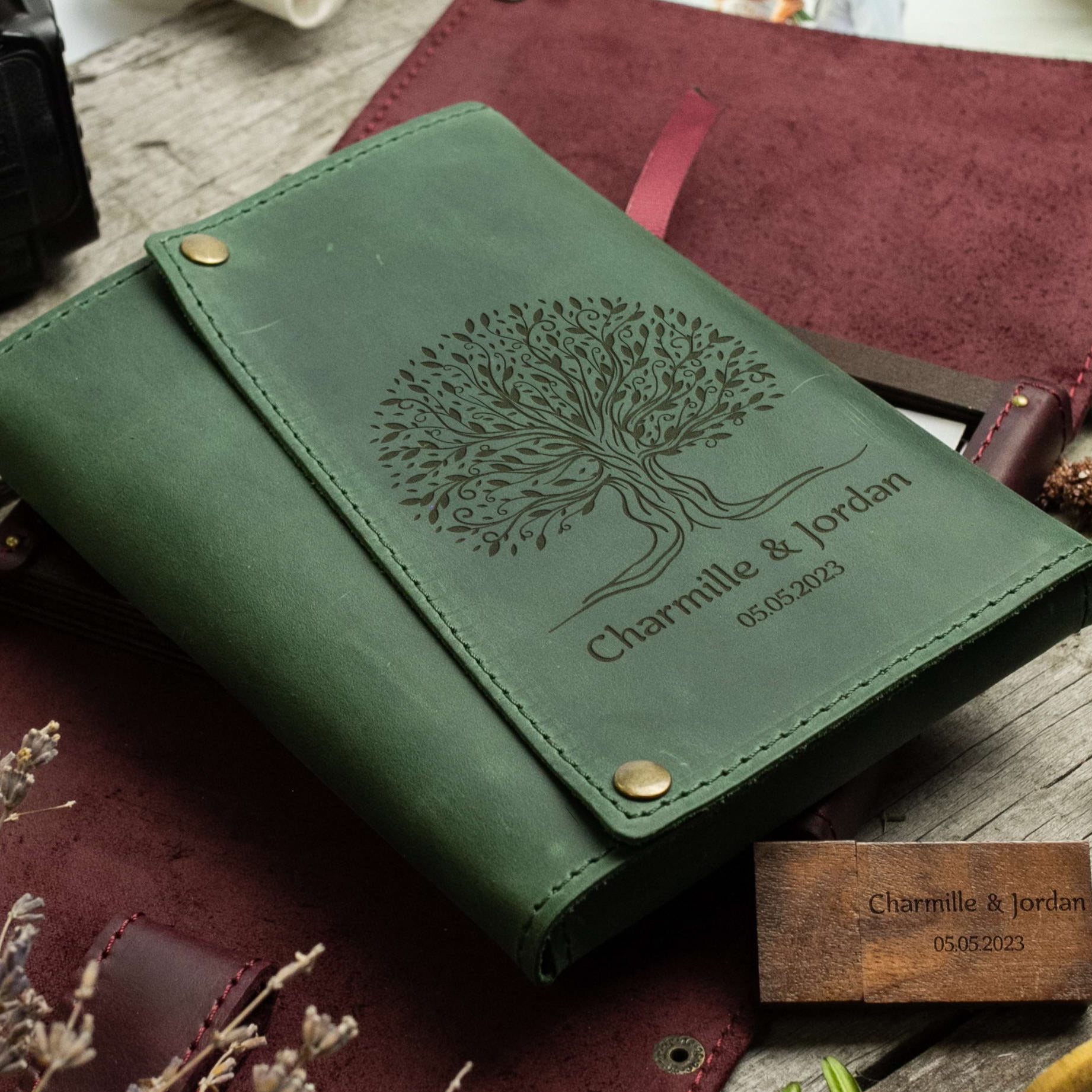 A green leather-bound notebook with a tree design and the names 'Charmille & Jordan' printed on it, along with a date '05/05/2023'.