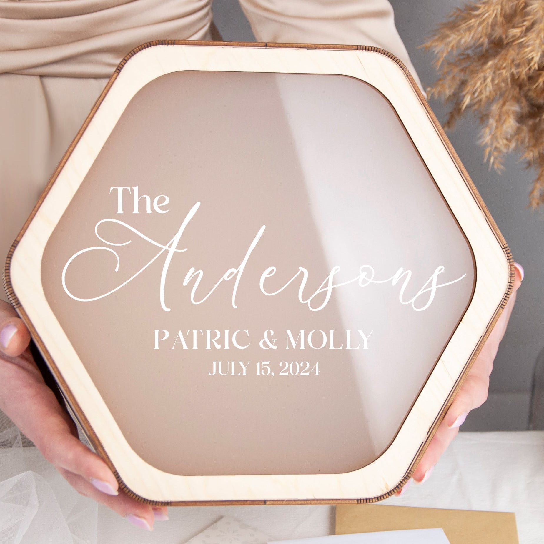 A person is holding a hexagonal frame with text on it, which appears to be a wedding or anniversary card.